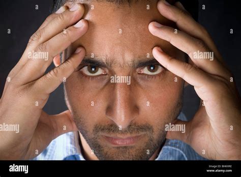 Serious man head in hands staring at camera Stock Photo - Alamy