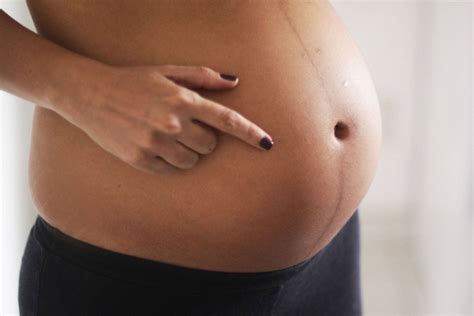 Download Pointing To Pregnant Belly Wallpaper | Wallpapers.com
