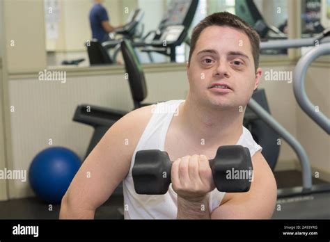 Man with Down Syndrome exercising in a gym with dumbbell Stock Photo ...