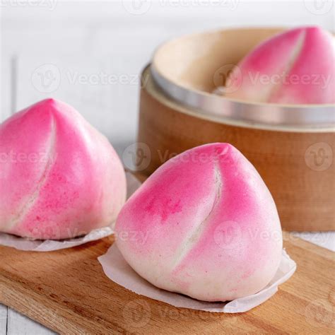 Pink Chinese peach birthday bun food on white table background