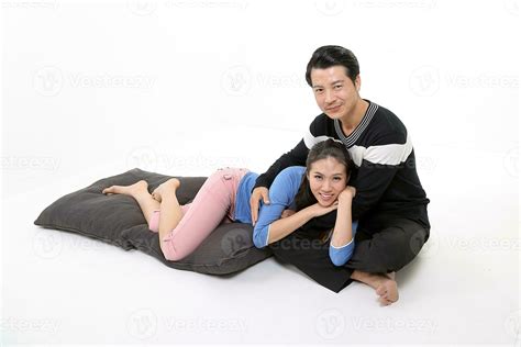 South East Asian young Chinese couple husband wife on floor resting on