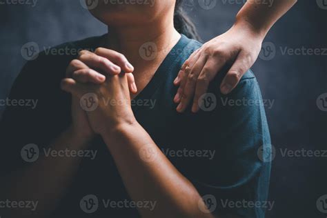 Woman laying hands on a young female christian shoulder to empower and