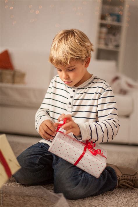 "Cute Boy Opening Christmas Gift At Home" by Stocksy Contributor ...