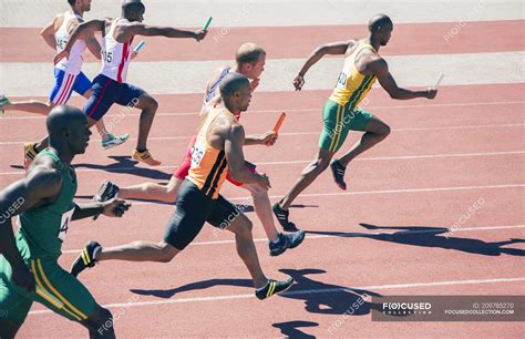 Relay runners racing on track — athletic, people - Stock Photo | #209785270