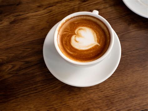 Premium Photo | Hot coffee with soft bubble on old wooden boards.