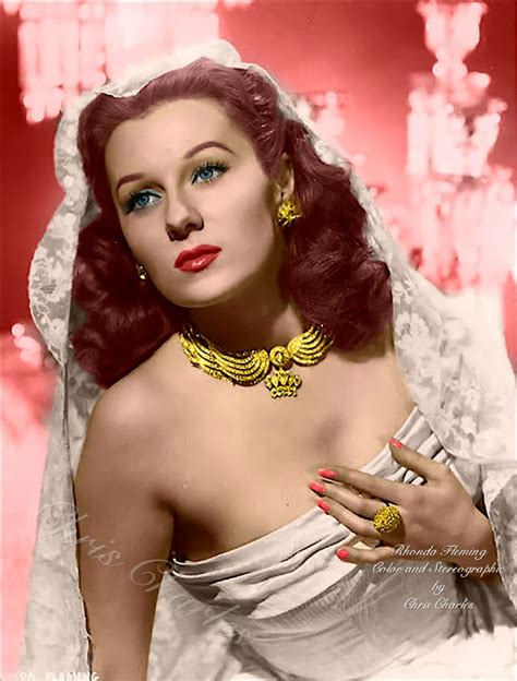 a woman with red hair wearing a white dress and gold jewelry on her ...
