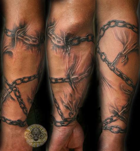 two men's legs with chains and skulls on them, both covered in black ink