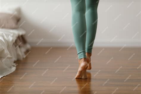 Premium Photo | Young woman in sports leggings walks barefoot on the ...