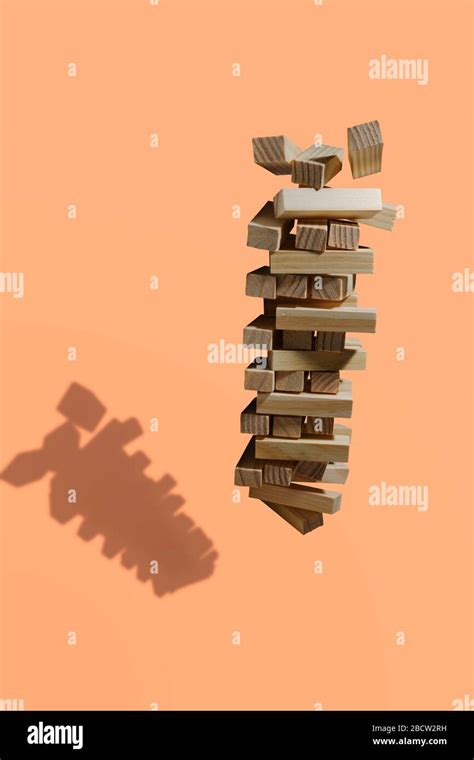 wooden block tower game collapses isolated  orange background