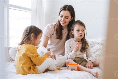 joven familia feliz con una madre madre con dos hijos niñas comiendo