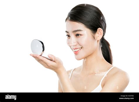 Side view portrait of young smiling Korean woman holding and looking at ...
