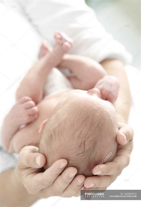 Close-up of mother hands holding newborn baby boy. — parent, innocent