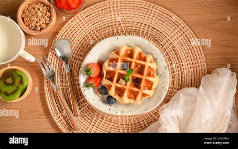 homemade waffle served  honey syrup  fresh berries warm milk