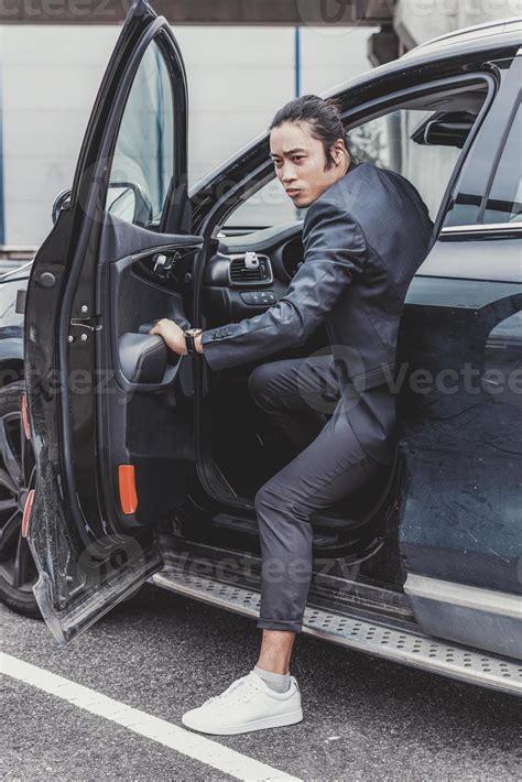 Asian business man getting out of his car on the parking lot 15985990