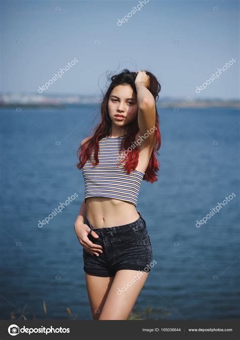 Sexy, linda jovencita tocándose el pelo. Un adolescente sobre un fondo