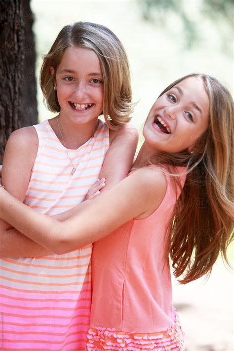 "Twin Sisters Hugging And Laughing" by Stocksy Contributor "Dina Marie