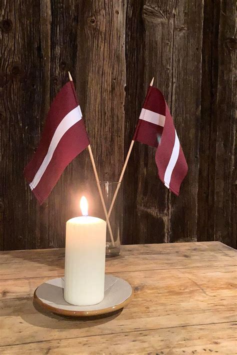 a candle with two flags on it sitting in front of a wooden wall and table