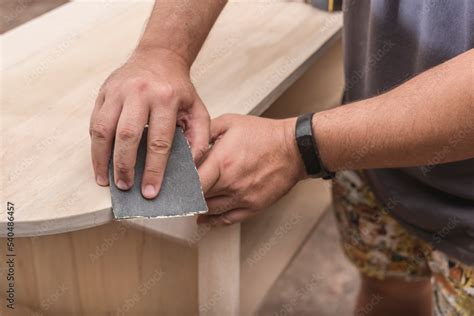 man   piece  sandpaper  smooth   edge   circular
