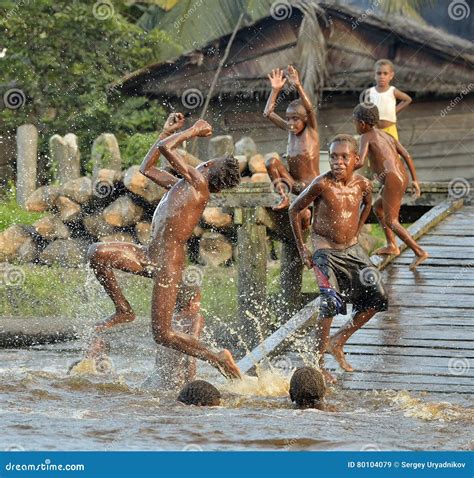 Children of the Tribe of Asmat People Bathe and Swim in the River