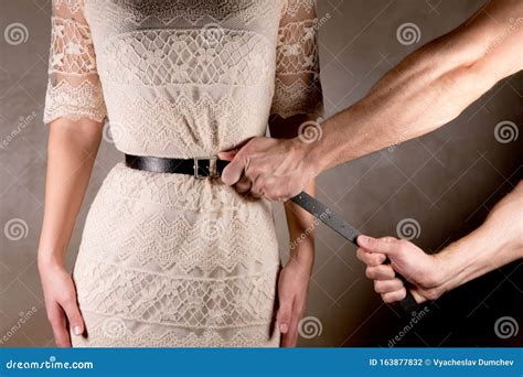 man tightly tightens  belt   woman  waist stock photo image