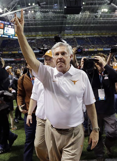 Sporting News: Texas coach Mack Brown, center, holds up the...