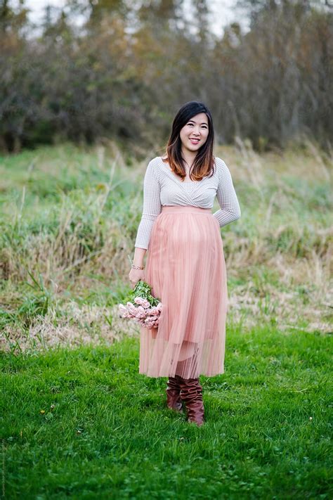 "Portrait Of Pregnant Asian Woman Outdoor In A Park" by Stocksy