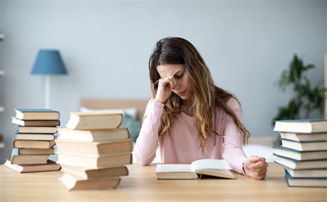 sad young woman  books sit  work desk stock photo