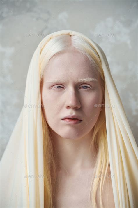 Young serene albino woman with white cover on head Stock Photo by Pressmaster