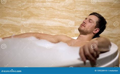 handsome man enjoying aroma  hot water  bath  foam