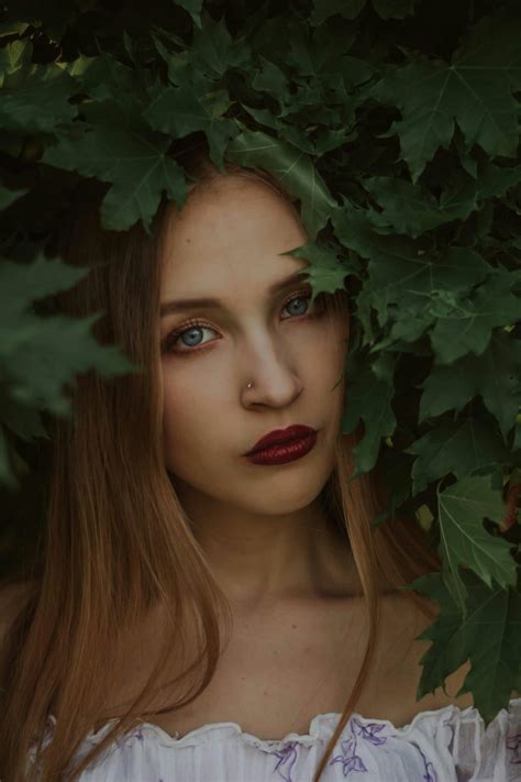 Portrait of Woman Sitting under Flowering Plant · Free Stock Photo