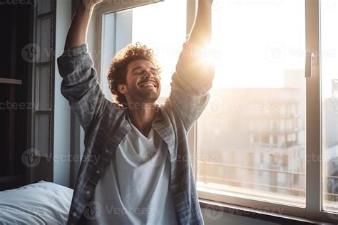 Handsome Young Man Waking up in the Morning, Stretches and Gets Out of