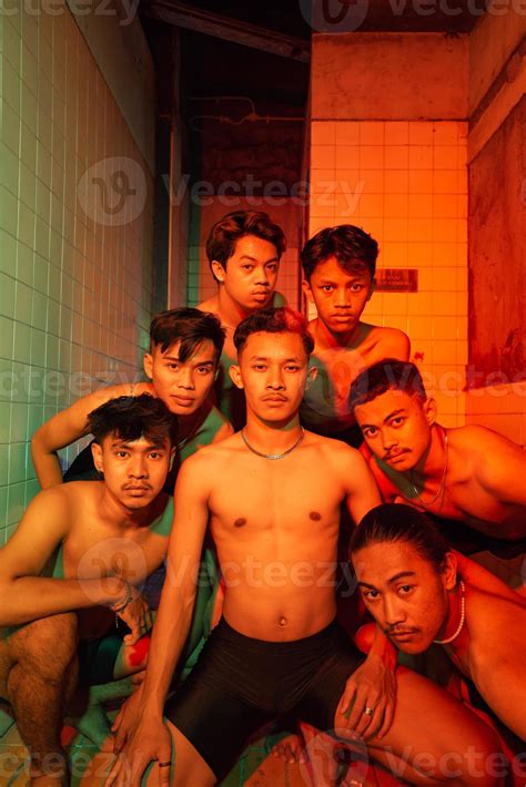 a group of naked gays are gathering and posing with their friends while