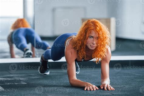haciendo tablón. la chica pelirroja deportiva tiene un día de fitness
