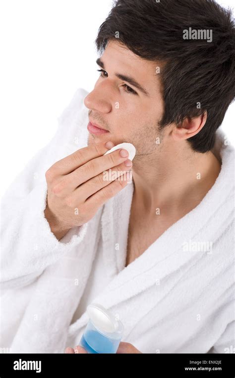 Facial care - Young man cleaning face with lotion Stock Photo - Alamy