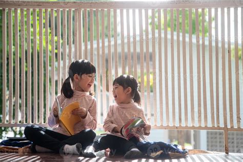 Cute Asian siblings girl reading a book at home. 13066069 Stock Photo