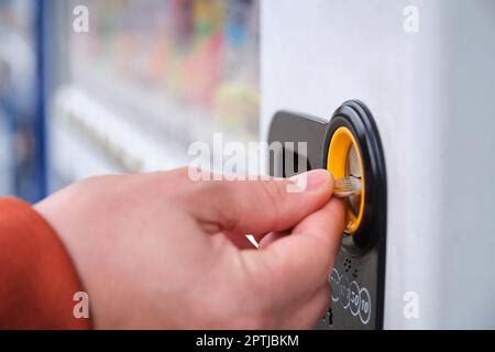 Hand paying 100 yen to get a drink in a japanese vending machine ...