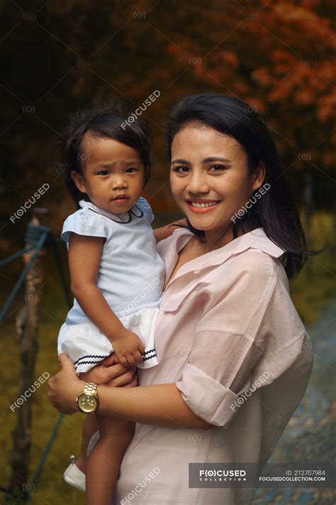 Cute asian mother and daughter hugging in park, portrait — shoe, girl
