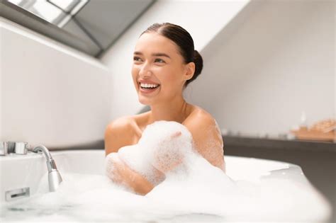 Premium Photo | Joyful lady washing body sitting in bathtub taking bath ...