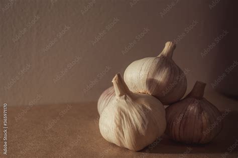 Cabeças de alho com iluminação lateral na mesa da cozinha Stock Photo | Adobe Stock