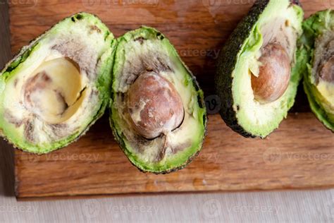 rotten avocado cut    wooden background  stock photo