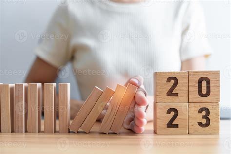 Hand stop falling blocks with 2023 year. Risk Management, recession