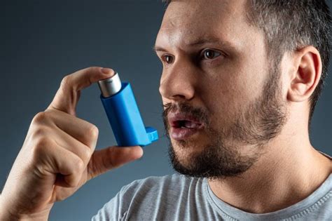 Портрет мужчины с астмой ингалятор в руках, приступ астмы. концепция ...