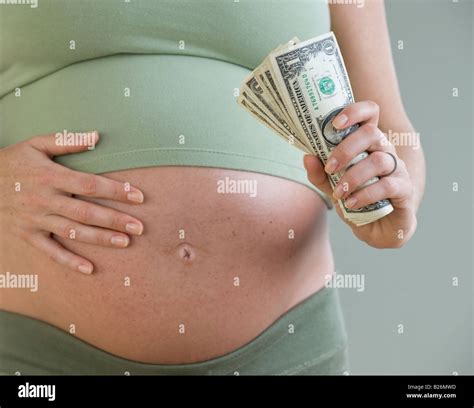 pregnant woman holding money stock photo alamy