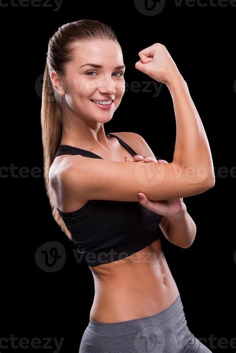 Measuring her perfect bicep. Sporty young woman touching her bicep and