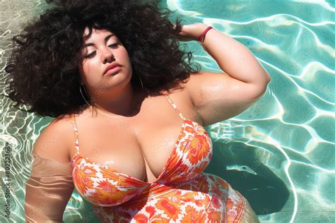 curvy latina enjoying  swimming pool stock photo adobe stock