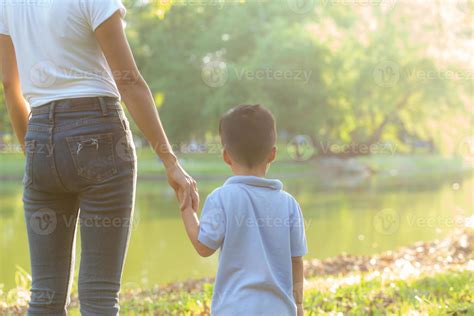madre asiática o padre e hijo tomados de la mano con amor juntos en
