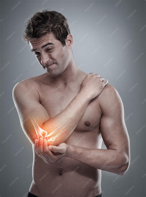 Premium Photo | That old injury a young man holding his inflamed elbow