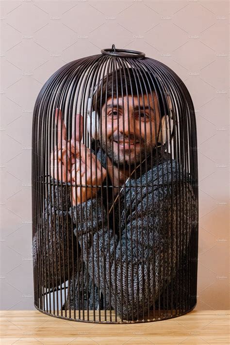 Man locked in a cage stock photo containing cage and man | People