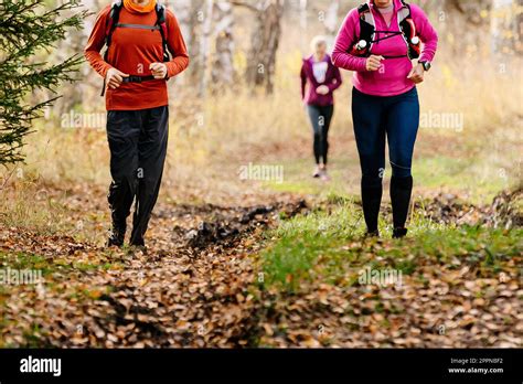woman  man runners run autumn trail marathon  fallen leaves