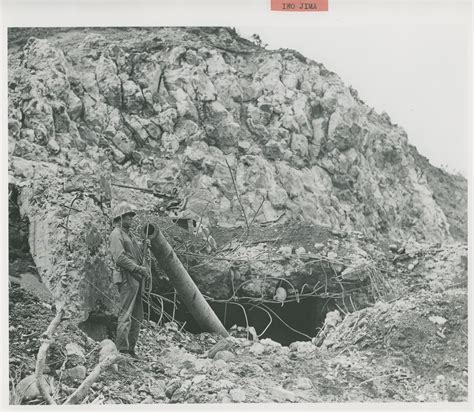 US Soldier guards destroyed Japanese artillery piece on Mount Suribachi